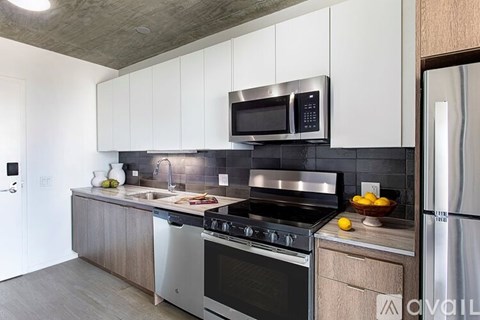 A modern kitchen with stainless steel appliances and wooden cabinets.