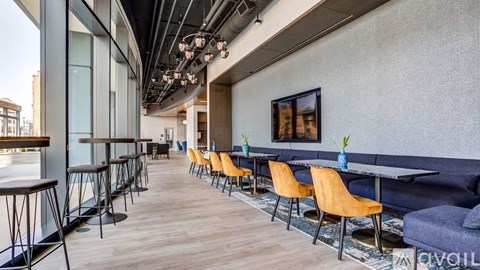 A modern dining area with wooden floors and a mix of black and brown furniture.