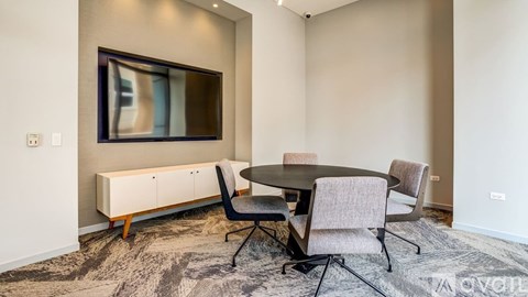 A modern living room with a television, a sofa, and a dining table.
