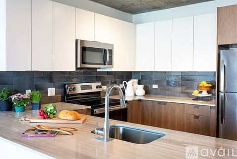 A kitchen with a wooden countertop and a stainless steel refrigerator.