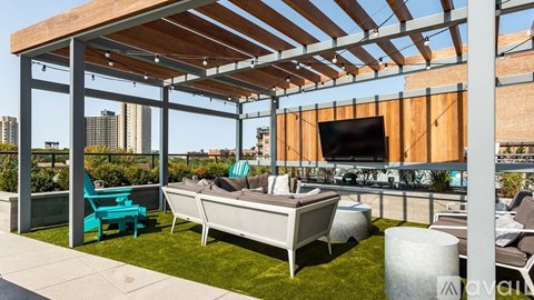 A patio with a white couch and a blue chair under a wooden pergola.