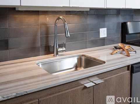 A modern kitchen with a stainless steel sink and wooden countertop.