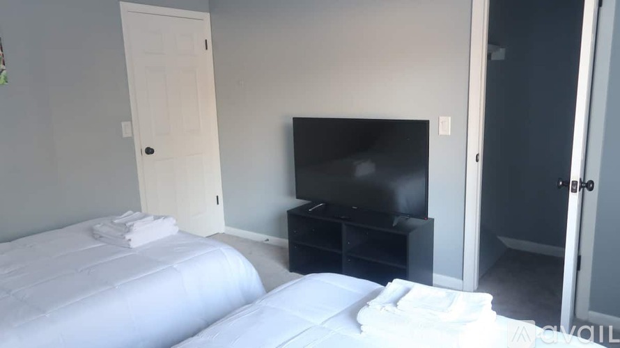 A bedroom with a bed, a television, and a door.