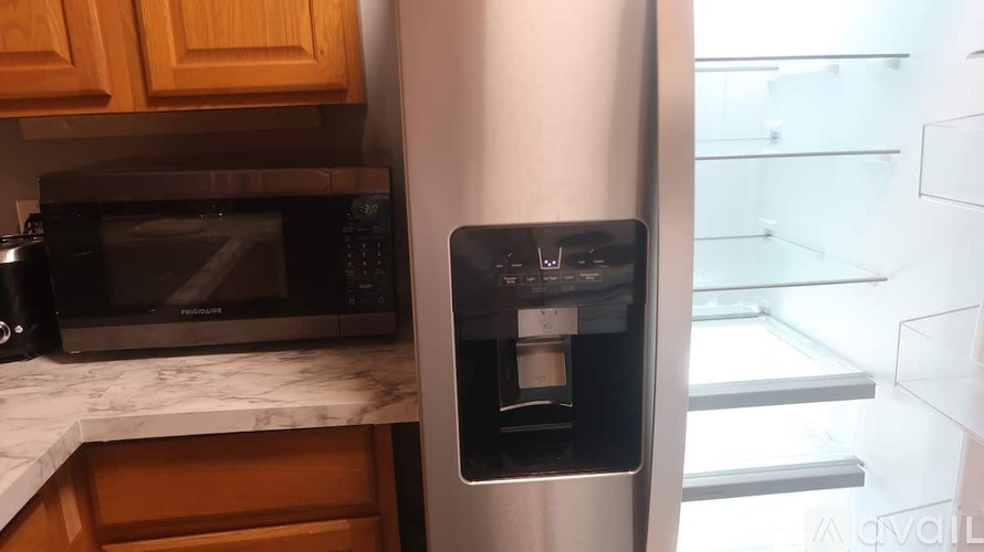 A black microwave oven is on a kitchen counter.