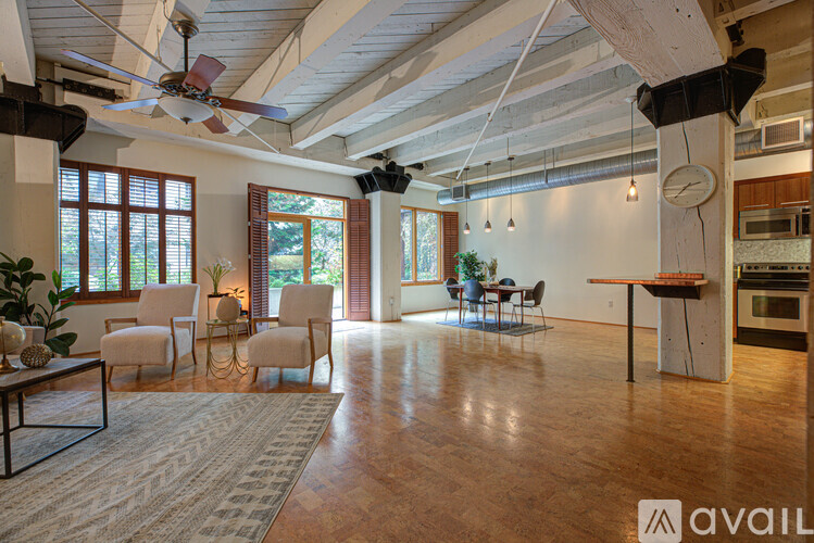 A living room with a fan, chairs, and a dining table.