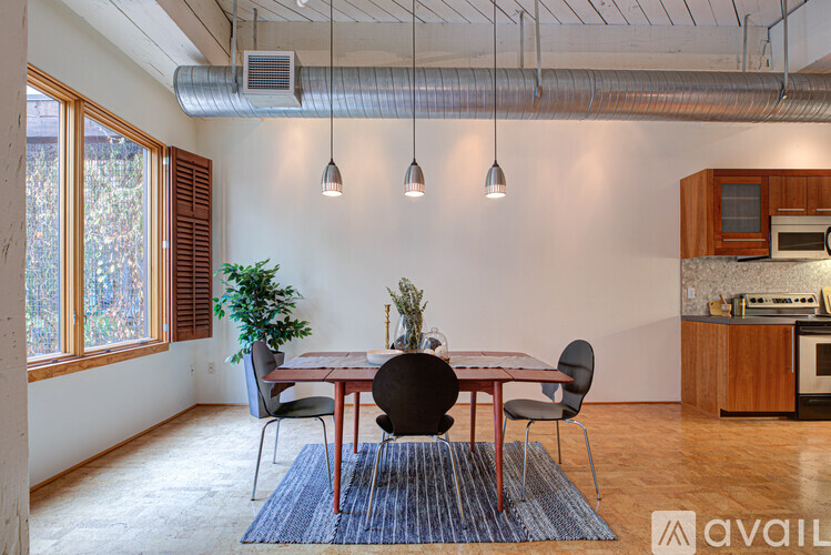 A dining room with a table and chairs and a plant.