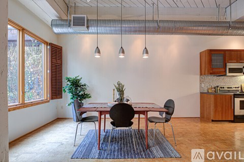 A dining room with a table and chairs and a plant.