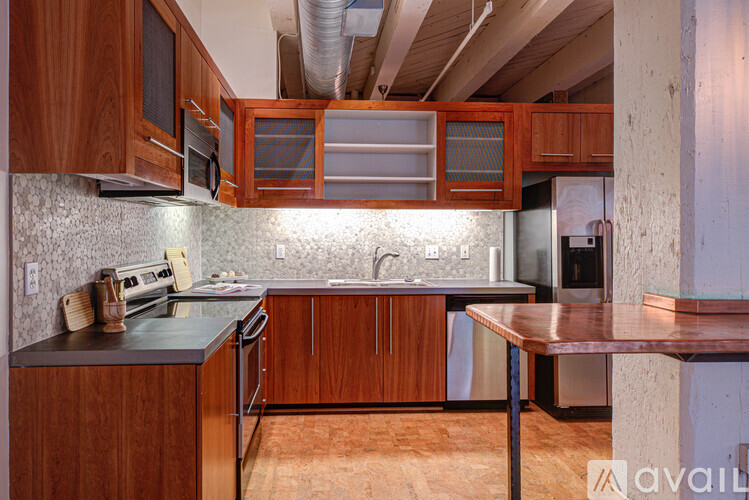 A kitchen with wooden cabinets and a black countertop.
