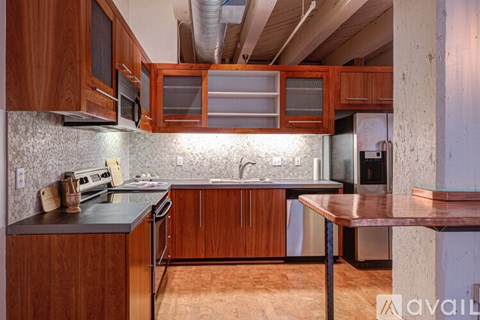 A kitchen with wooden cabinets and a black countertop.