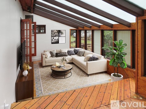 A living room with a couch, coffee table, and a TV on a wooden stand.