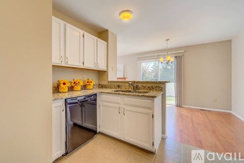 A kitchen with white cabinets and a granite countertop.