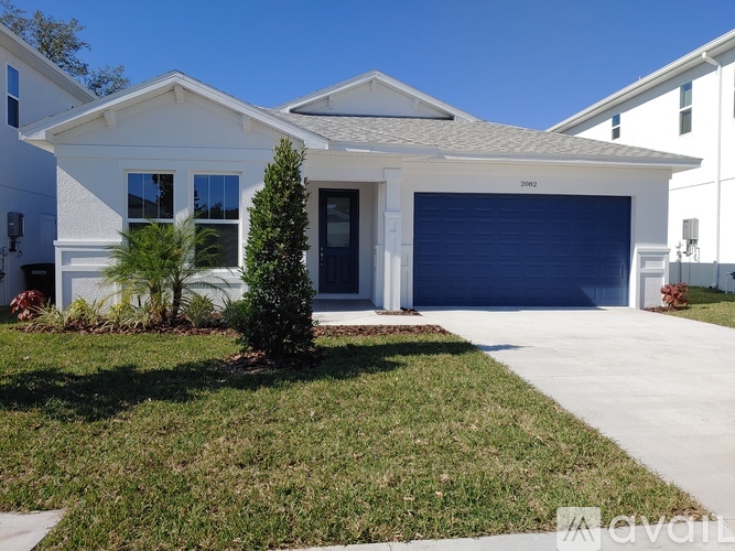 A white house with a blue garage door is for sale.