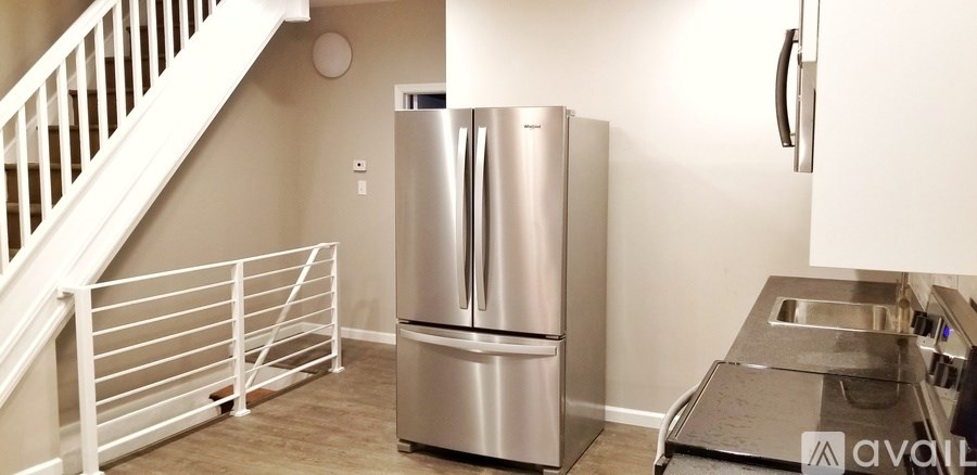 A kitchen with a stainless steel refrigerator and a sink.