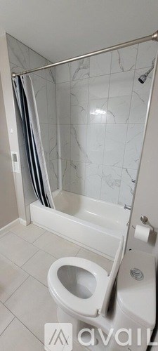 A white toilet in a bathroom with a marble shower.
