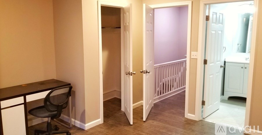 A room with a desk and a chair in it.