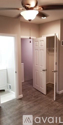 A room with a ceiling fan and a door.