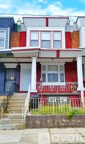 A red and white house with a porch and stairs leading up to the front door.
