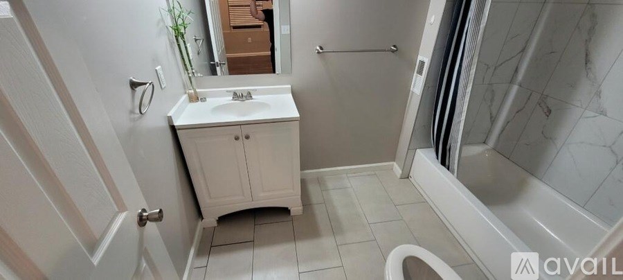 A bathroom with a white sink and a white cabinet.