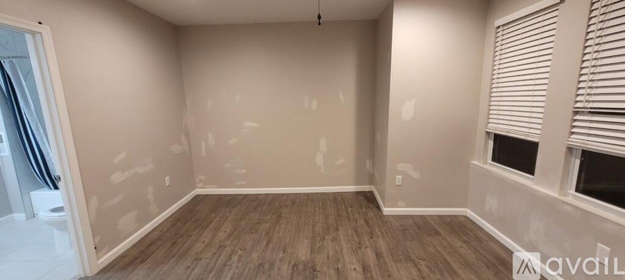 A room with wooden floors and walls covered in drywall.