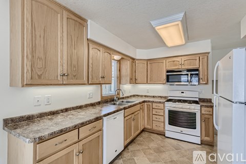 A kitchen with wooden cabinets and a granite countertop.