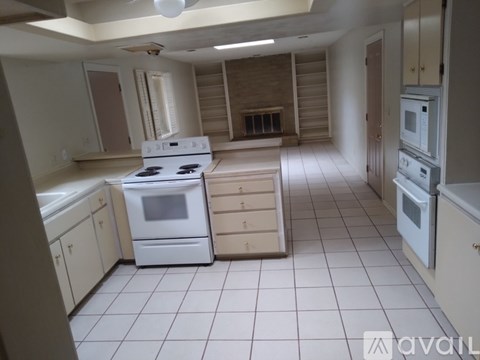 A kitchen with white appliances and cabinets is available for rent.