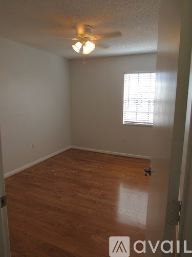 A room with wooden floors and a ceiling fan.