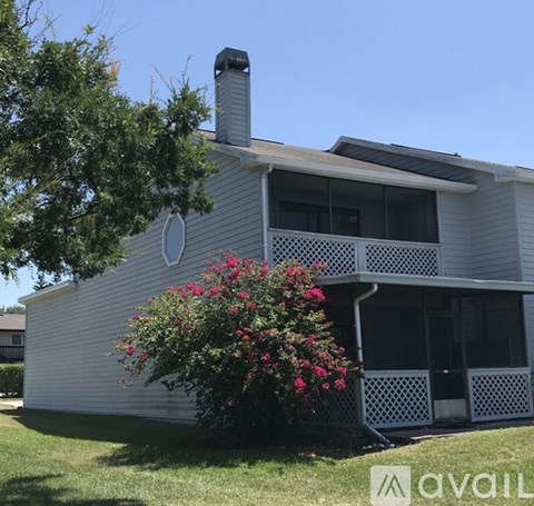 A house with a white exterior and a large window on the second floor.