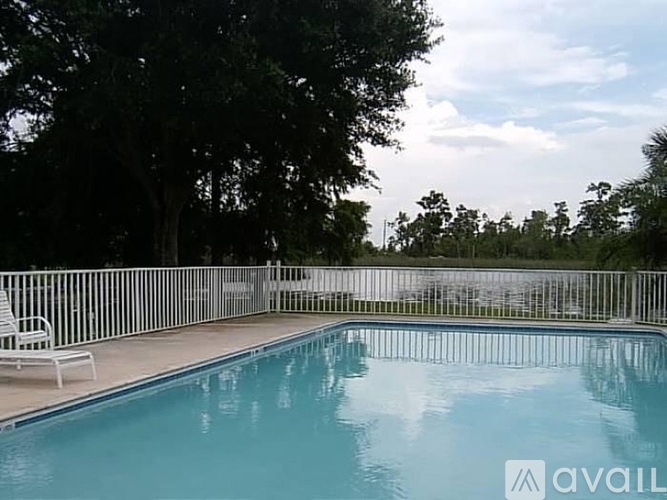 A pool with a white chair and a fence around it.