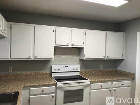 A kitchen with white cabinets and a stove top oven.