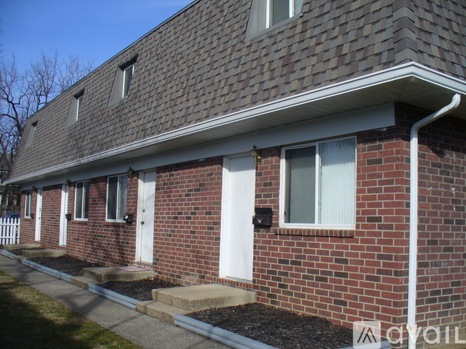 A red brick house with a white door and windows.