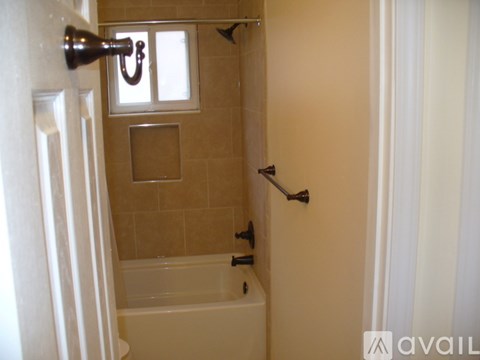 A bathroom with a tub and a window.