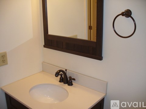 A bathroom sink with a brown mirror above it.