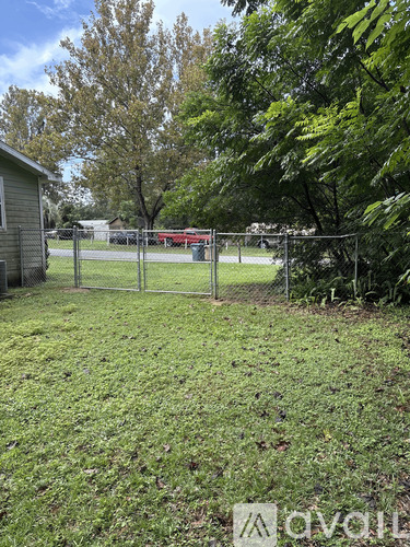 A white door with a window in the middle is on a green house.