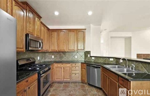 A kitchen with wooden cabinets and a black stove top oven.