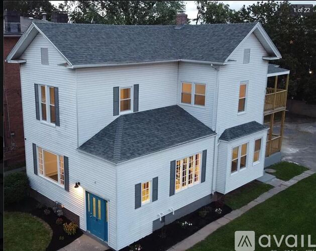 A white house with a blue door is for sale.