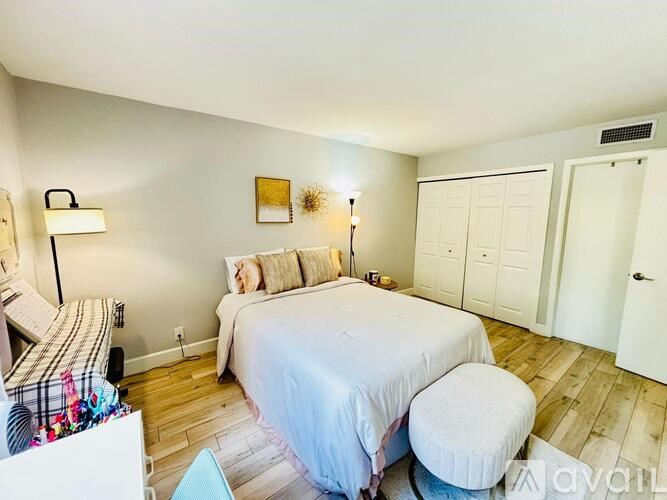 A bedroom with a bed, a chair, and a couch.