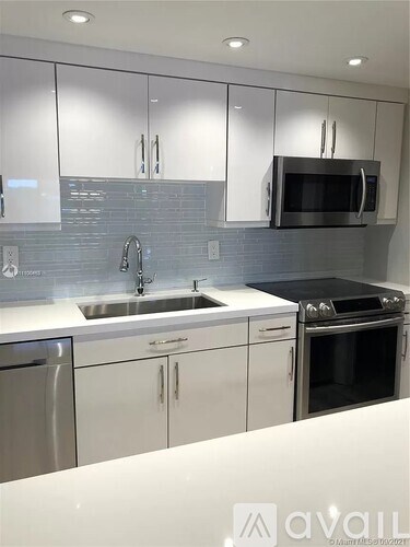 A kitchen with white cabinets and a stainless steel dishwasher.