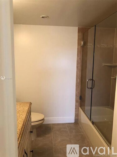 A bathroom with a toilet, a walk-in shower, and a glass door.