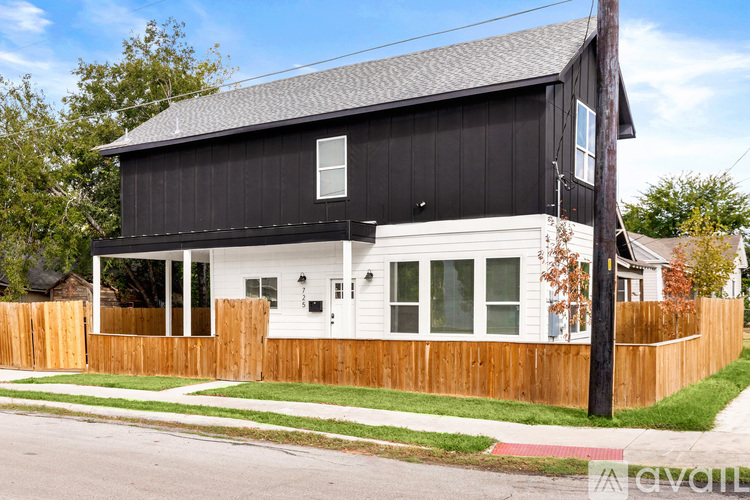 A black and white house with a wooden fence.