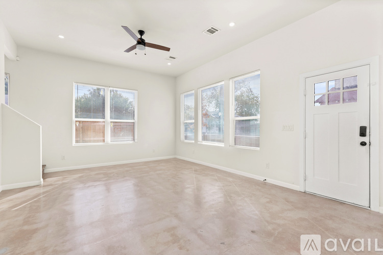 A spacious room with a ceiling fan and large windows.