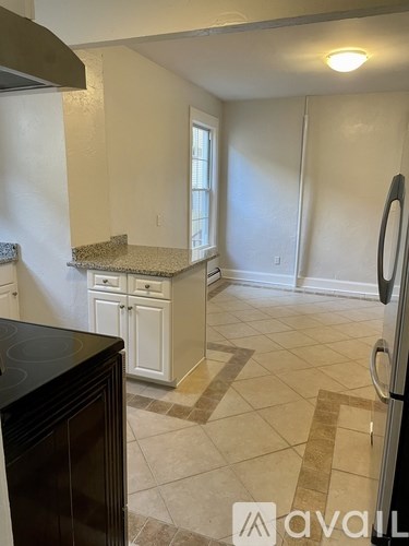 A kitchen with a black stove top oven and white cabinets.