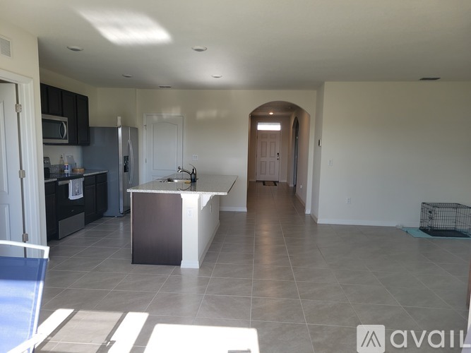 A kitchen with a refrigerator, microwave, and sink.