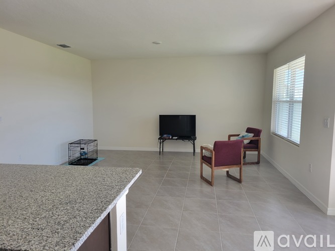 A living room with a television, two chairs, and a table.