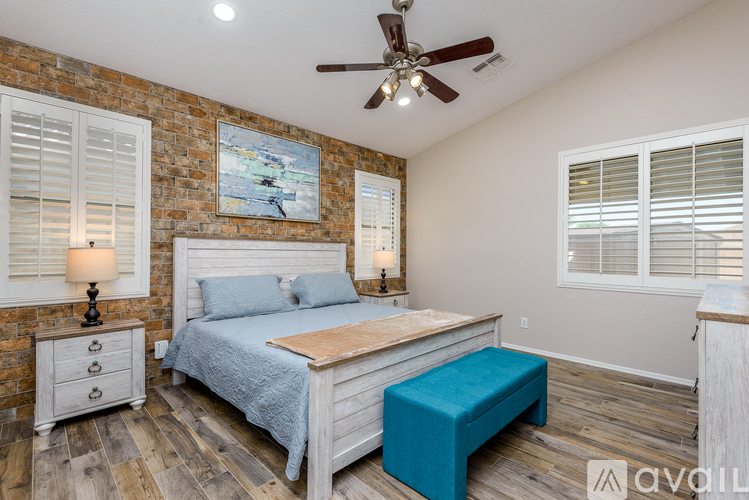 A bedroom with a bed, nightstand, and a ceiling fan.