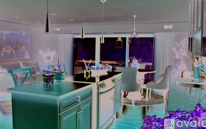 A kitchen with a green counter and white chairs.