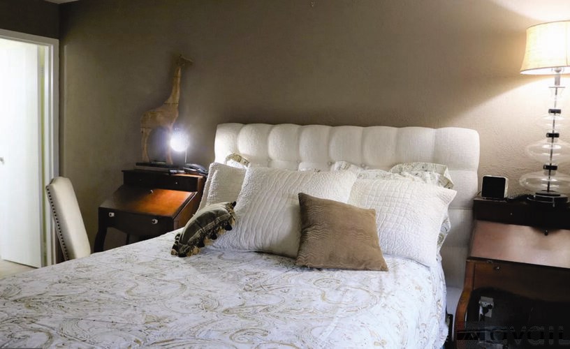 A bedroom with a bed, nightstand, and window.