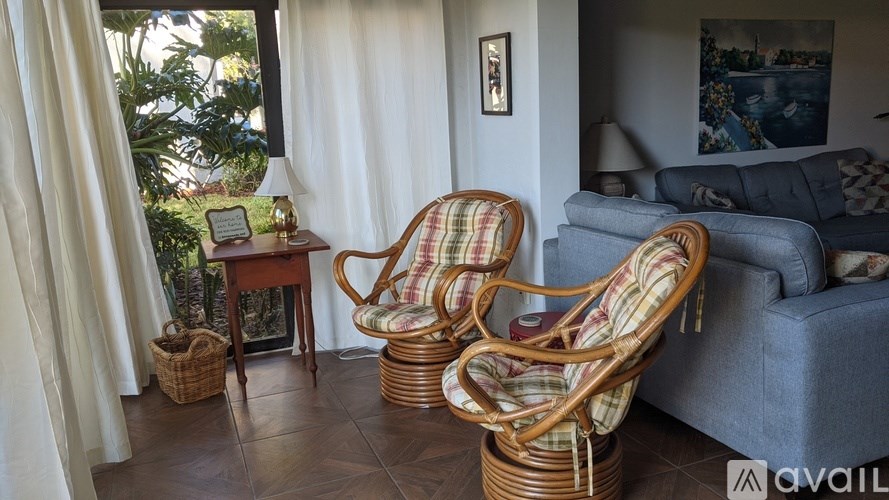 Two wicker chairs are placed in a living room.