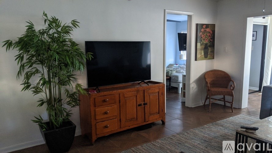 A living room with a flat screen TV and a wooden cabinet.