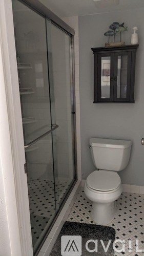 A white toilet in a bathroom with a glass shower door.
