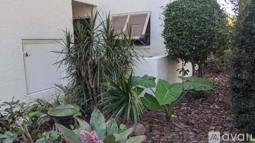 A white house with a garden in front.